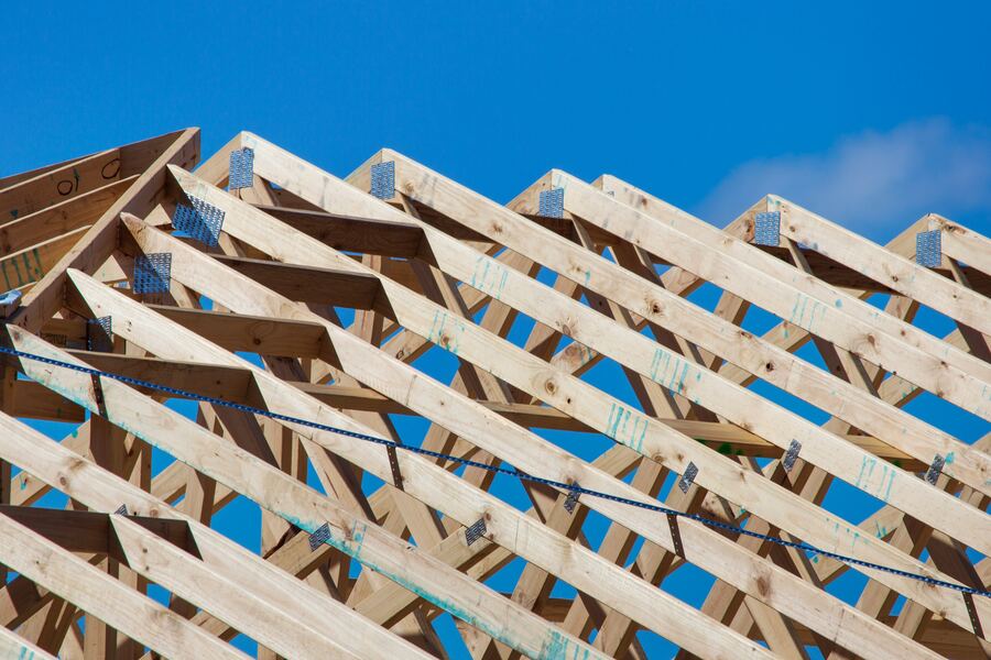 Roof trusses under construction against a blue sky